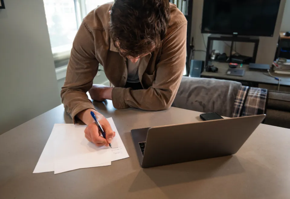 Person füllt am Laptop Formulare aus