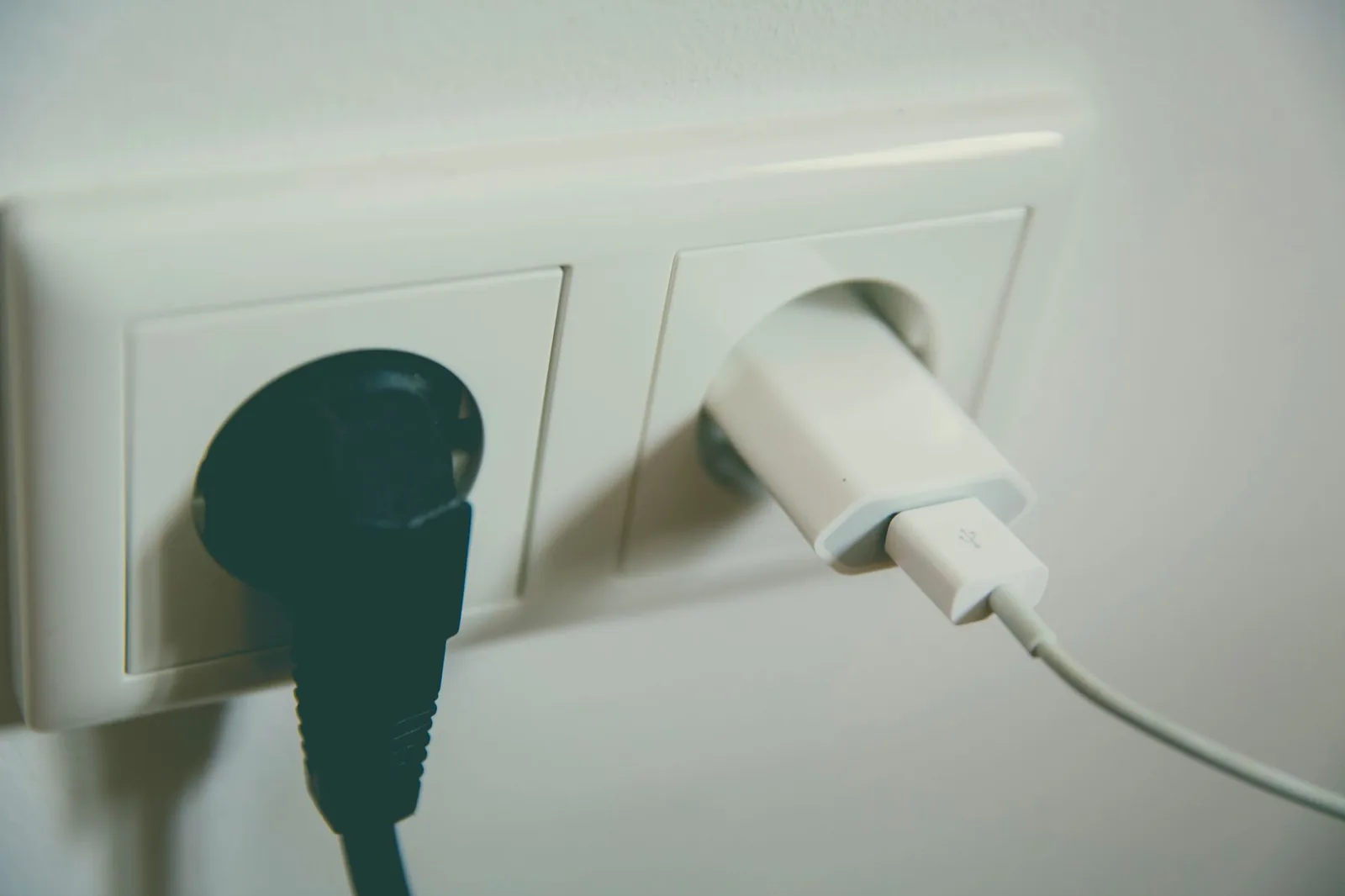 Stecker und Netzteil in einer Steckdose
